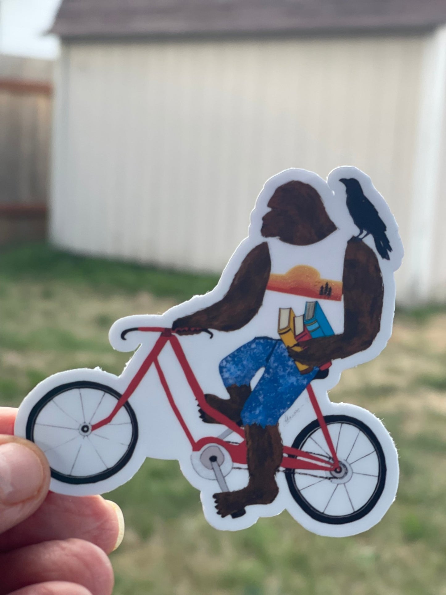 Bigfoot on Bike Sticker with Books and Crow – Whimsical Sasquatch Vinyl Decal Die Cut Sticker - Color Crumbs Club