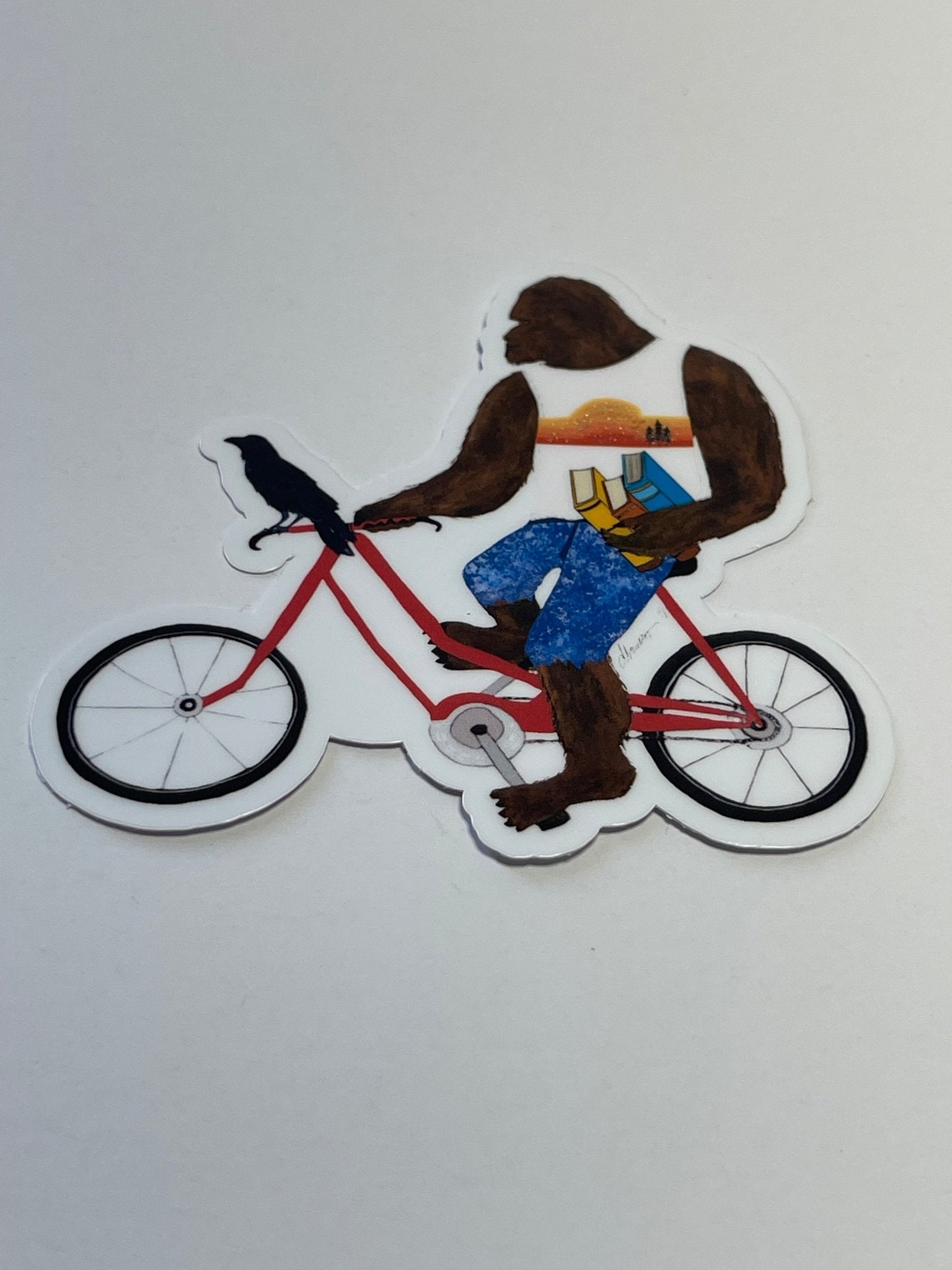 Bigfoot with books on bike with Crow – Whimsical Sasquatch Vinyl Decal Die Cut Sticker - Color Crumbs Club